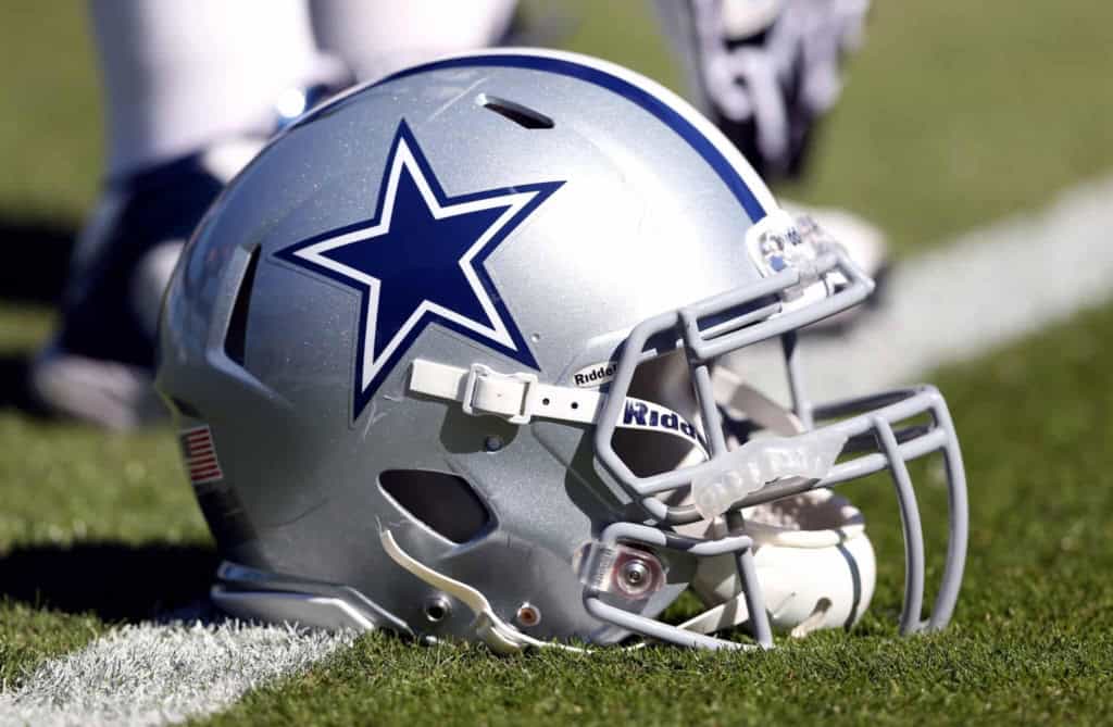 Dallas Cowboys football helmet on the grass, featuring team logo, NFL sports equipment, and game day gear, highlighting American football, Dallas Cowboys team spirit, and NFL branding.