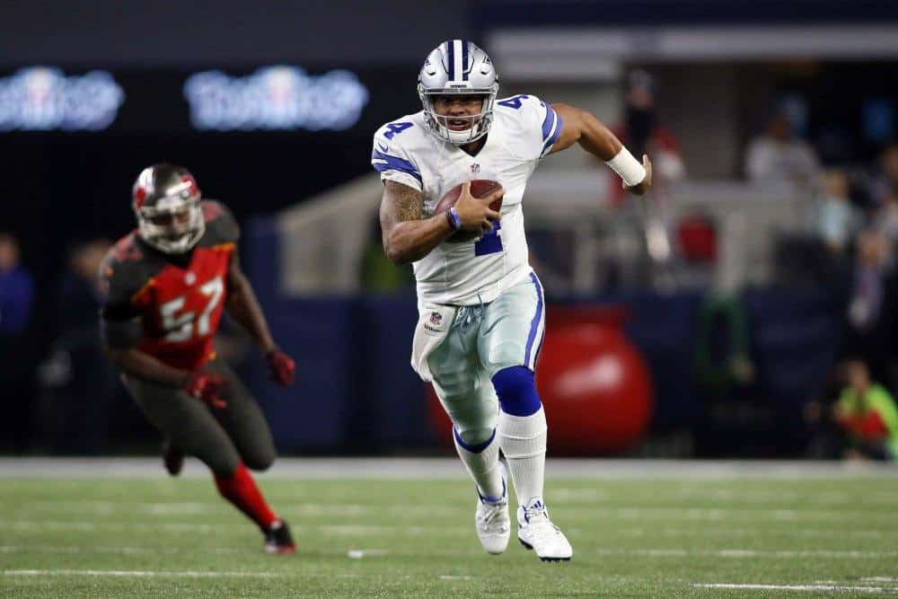 Dec 18, 2016; Arlington, TX, USA; Dallas Cowboys quarterback Dak Prescott (4) scrambles with the ball in the second quarter against the Tampa Bay Buccaneers at AT&T Stadium. Mandatory Credit: Tim Heitman-USA TODAY Sports