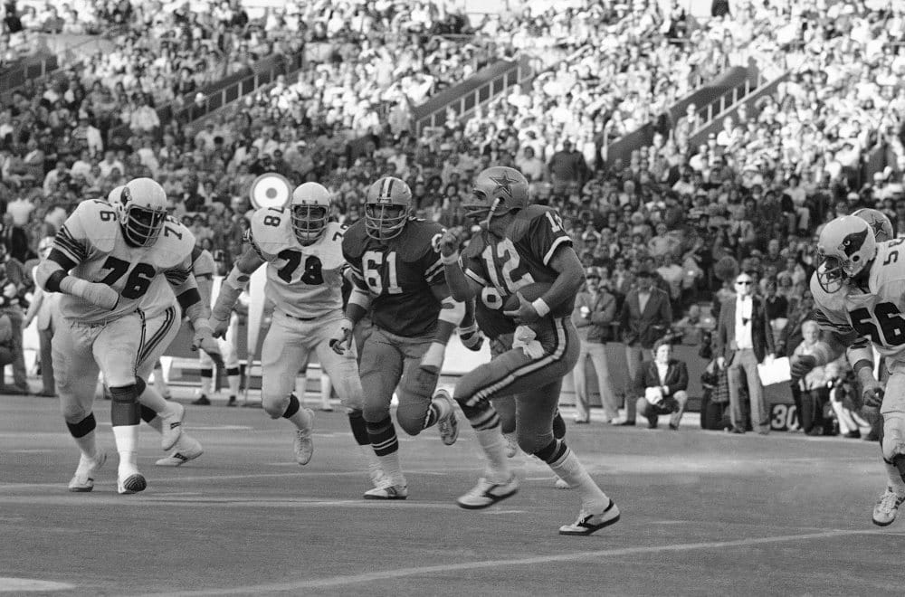 Dallas Cowboys quarterback Roger Staubach (12) runs run in a game against the St. Louis Cardinals, 1977. Cowboys Jim Cooper (61) runs along with Staubach; Cardinals Charlie Davis (76) and Ron Yankowski (78) give chase. (AP Photo)