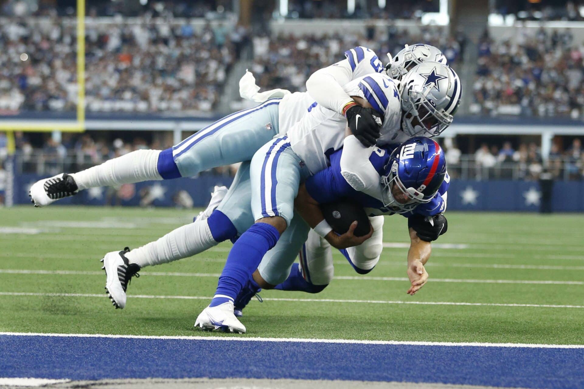 Oct 10, 2021; Arlington, Texas, USA; New York Giants quarterback Daniel Jones (8) is tackled by Dallas Cowboys linebacker Jabril Cox (14) and defensive end Chauncey Golston (59) in the second quarter at AT&T Stadium. Mandatory Credit: Tim Heitman-USA TODAY Sports