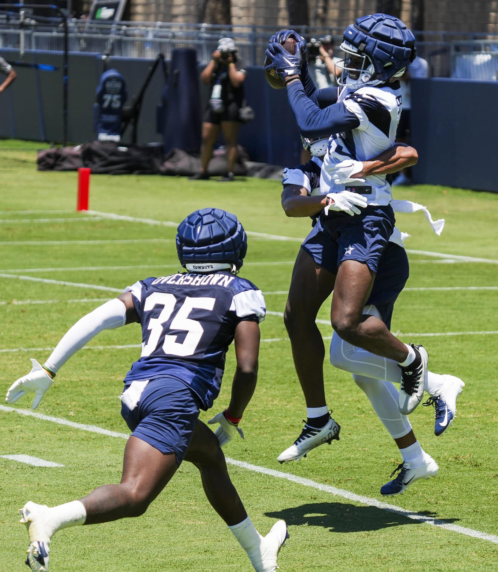 Dallas Cowboys wide receiver John Stephens Jr. (49) catches a touchdown pass as Dallas Cowboys safety Tyler Coyle (31) defends and linebacker DeMarvion Overshown (35) trails on the play during a training camp practice on Thursday, July 27, 2023, in Oxnard, Calif.