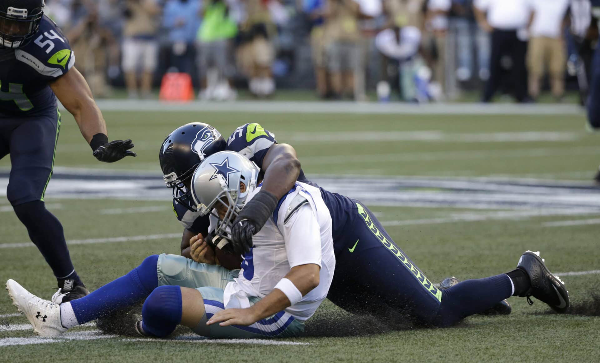 Cowboys QB Tony Romo gets tackled from behind in a preseason game versus Seattle.
