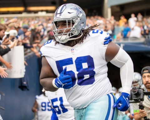 Football player wearing a Dallas Cowboys uniform with number 58 runs onto the field.