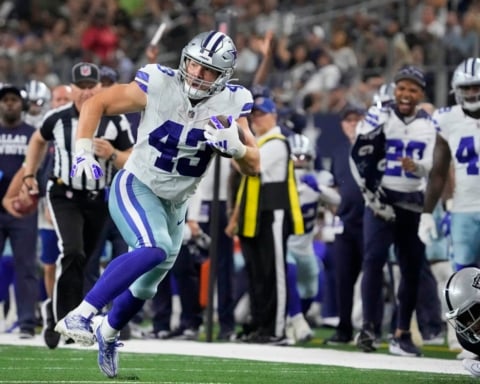 Hunter Luepke, in his Cowboys uniform, charges down the field with the ball, while both teammates and 49ers opponents focus on every move.