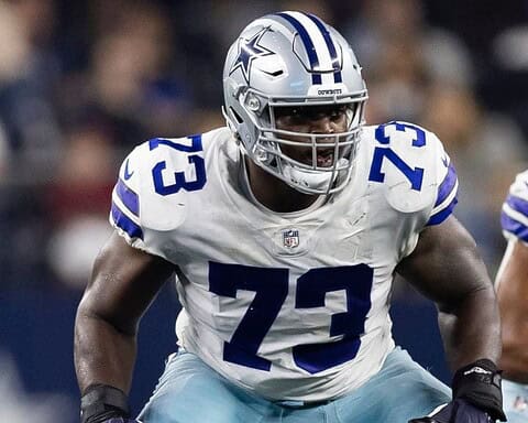 Tyler Smith, wearing number 73 in a white and blue uniform, prepares to block during the game.