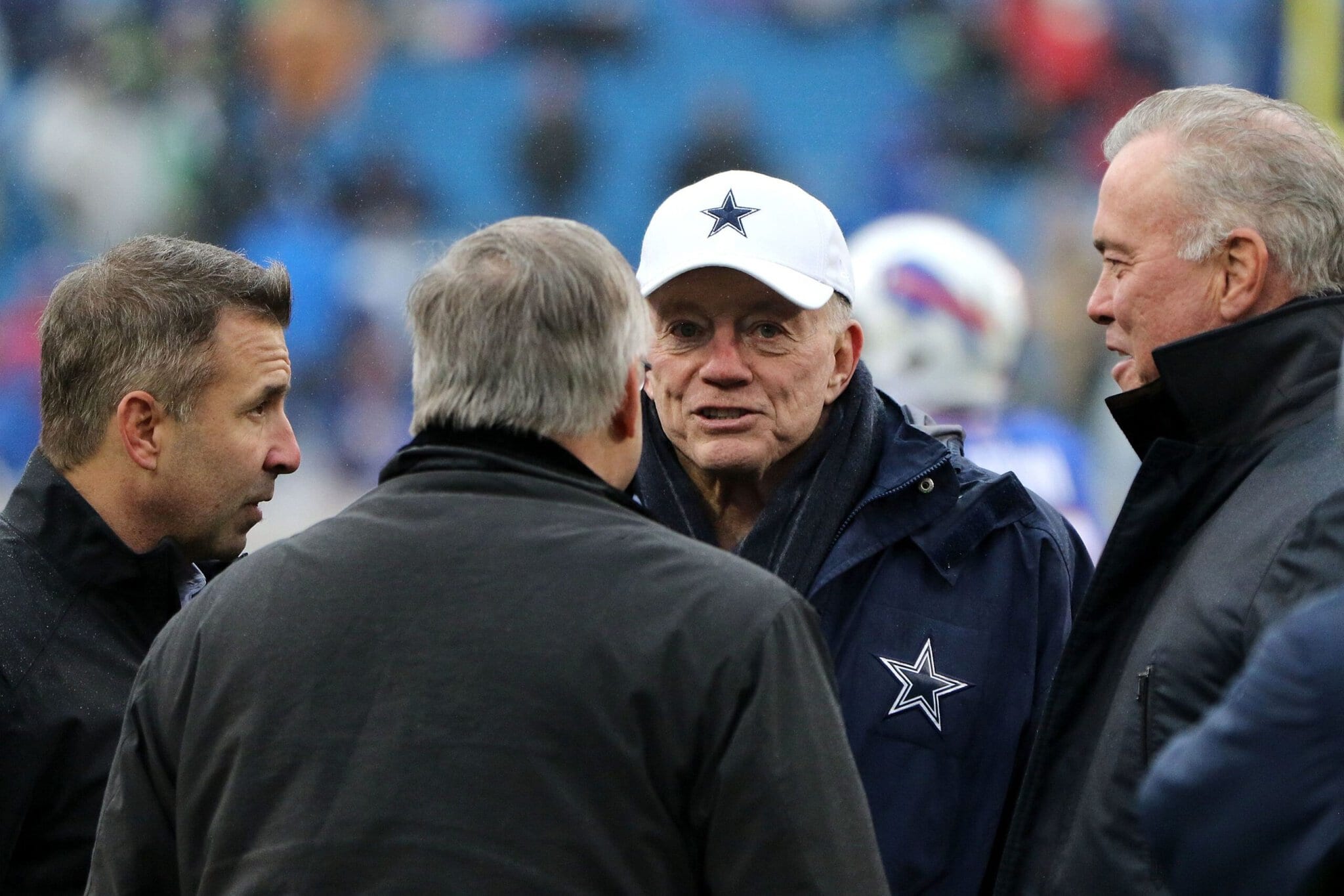 Jerry Jones and Stephen Jones talking with two other men at a football game