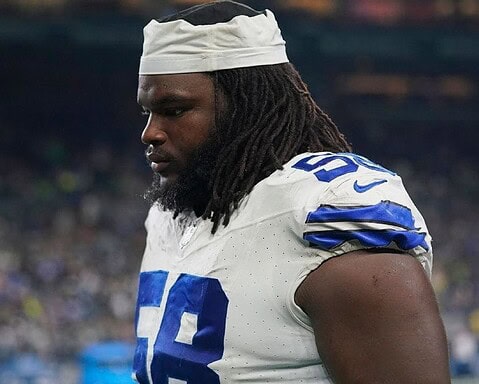 A football player in a white and blue uniform, numbered 68, standing on the field with a focused expression.