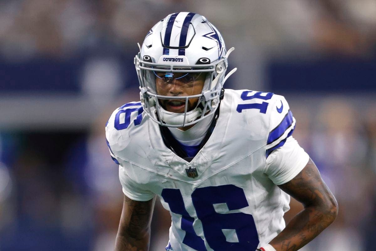 Football player in a blue and white uniform, wearing a helmet marked with "Cowboys," on the field during a game.