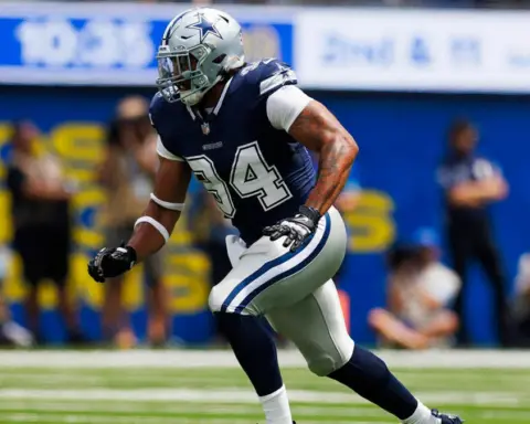 A football player in a blue and white uniform runs on the field during a game.