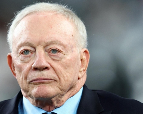 A man in a suit and tie looks ahead with a serious expression.