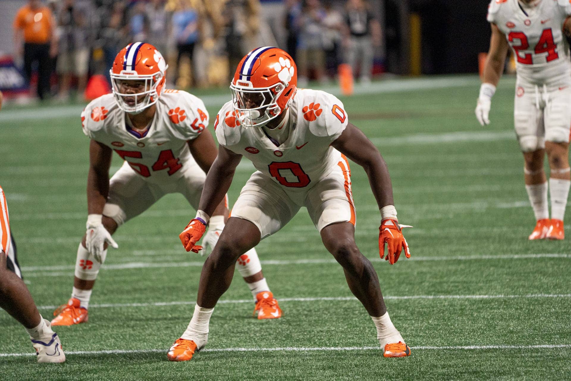 Football players in white uniforms, reminiscent of the Dallas Cowboys, focus intently on the action unfolding on the green field.