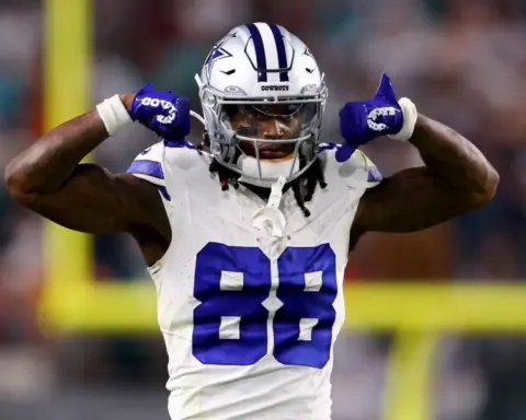 Cowboys player CeeDee Lamb flexes his arms triumphantly during a Week 11 game, showcasing his strength and determination on the field.