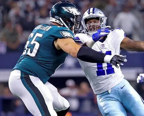 Two American football players from opposing teams engage in a fierce clash during a thrilling Week 10 game, with the ball cleverly concealed.