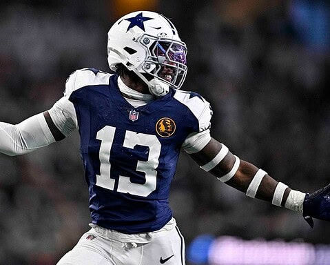 During a game, a football player in a blue and white uniform from the Cowboys draft class throws a precise pass, highlighting the team's 2024 resurgence.