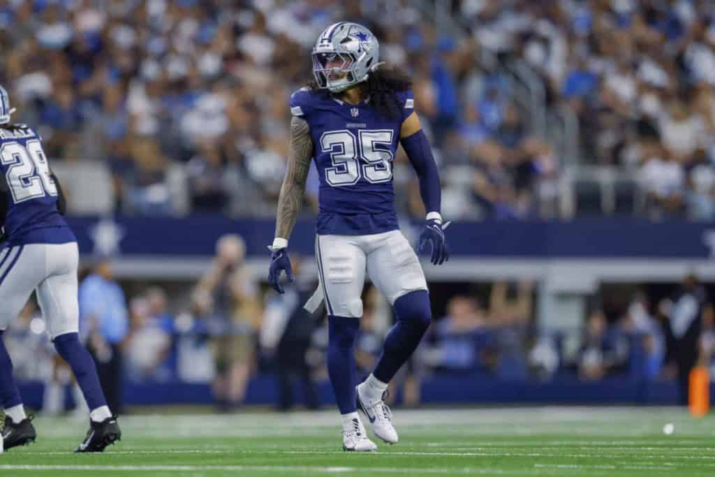 Dallas Cowboys football player in uniform on the field during a game, celebrating a play, with a crowd in the background.
