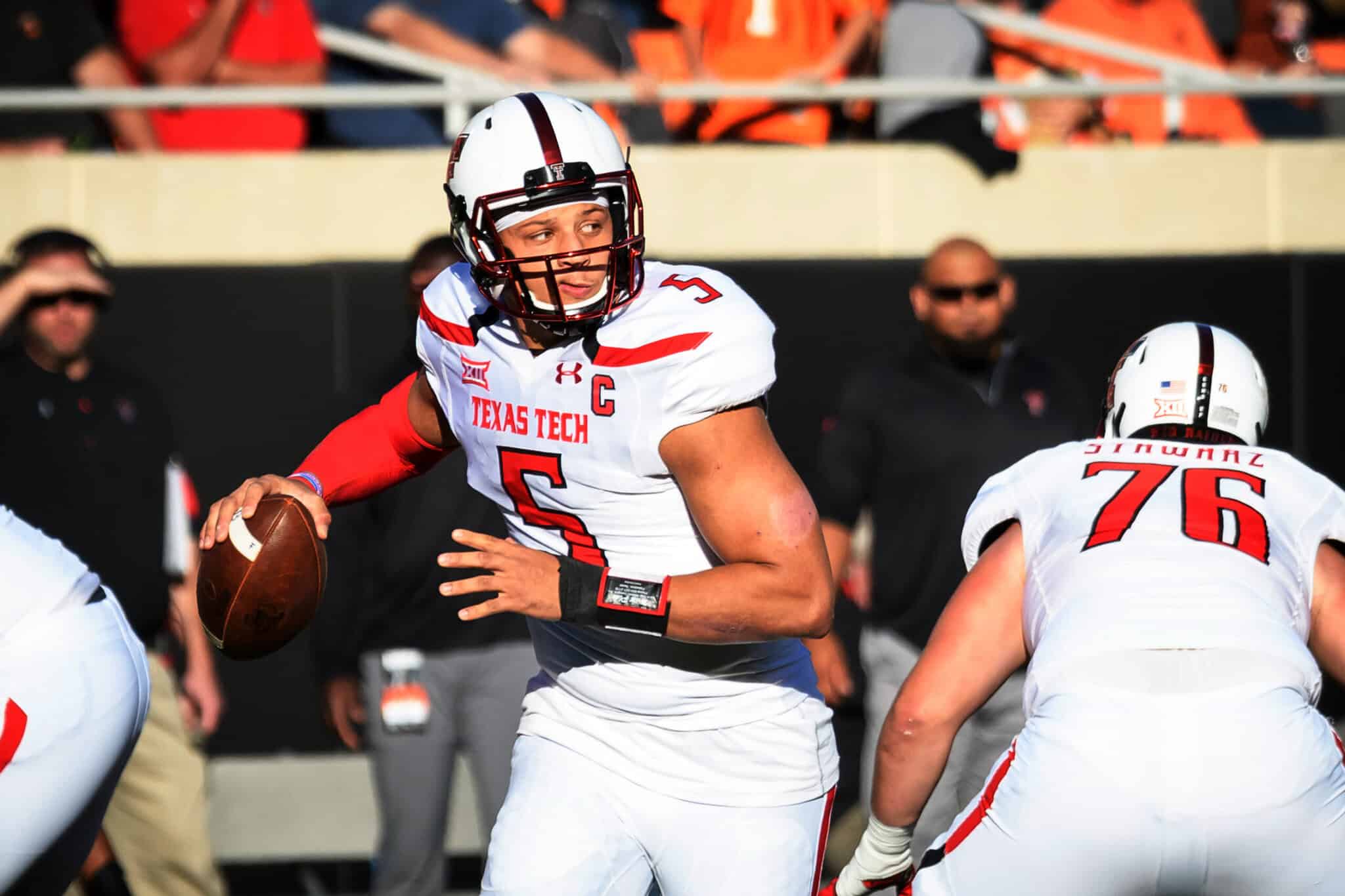Quarterback in Texas Tech football uniform preparing to throw a pass during a game.