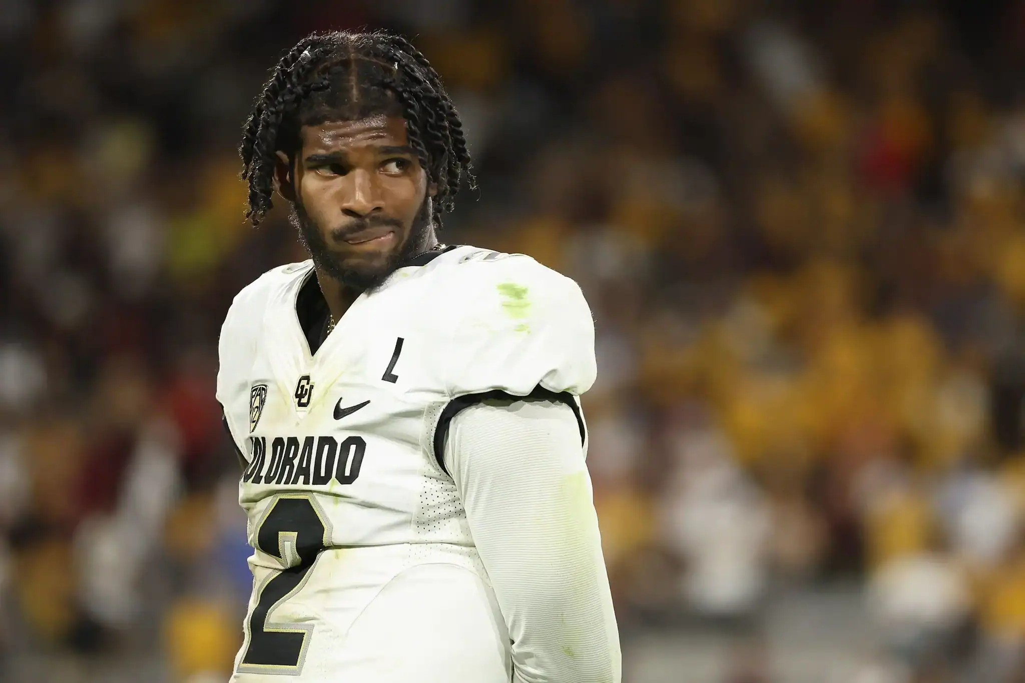 A football player with dreadlocks wearing an Colorado Buffaloes jersey on the field during a game.