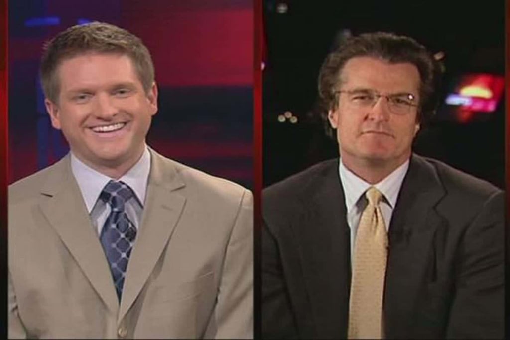 Smiling sports news anchor in beige suit on the left, serious analyst in dark suit and glasses on the right, inside the star TV set, Dallas Cowboys coverage, inside the star branding, professional sports broadcasting atmosphere.