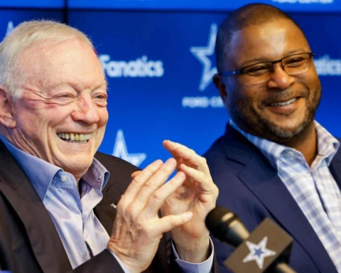 Cheerful Dallas Cowboys executives at a press conference or event, smiling and engaging with the audience, showcasing leadership and team spirit in the NFL sports industry.