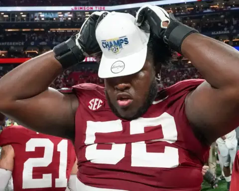 Inside the Star football player wearing a red jersey and white cap celebrating victory after winning the SEC Championship at Mercedes-Benz Stadium.