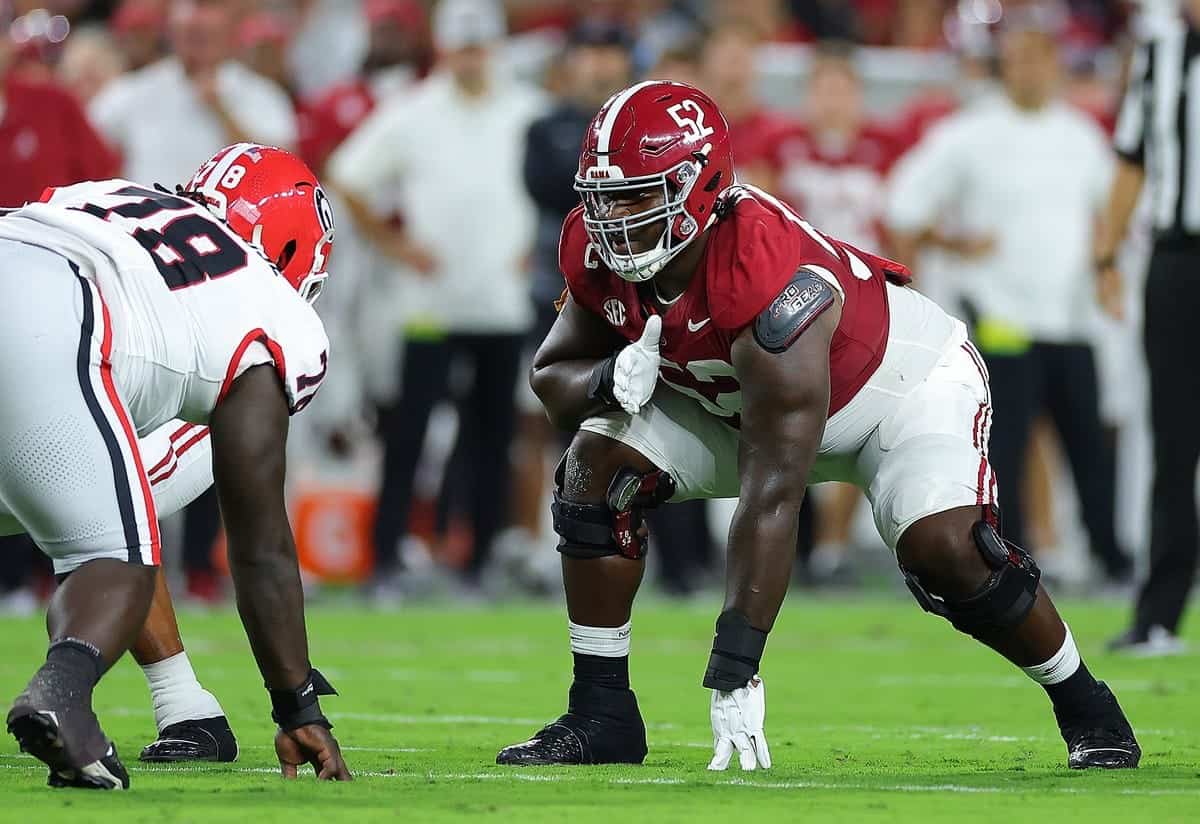 Alabama Crimson Tide football players lining up on the field during a game, showcasing intense athleticism and team strategy.