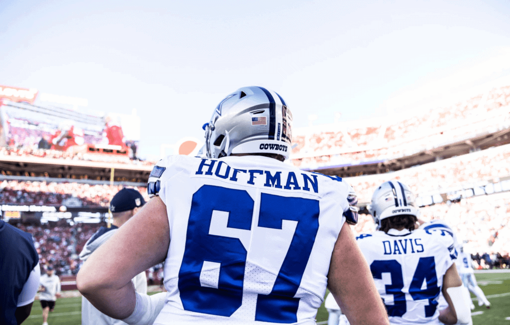Dallas Cowboys football player on the field during a game, wearing jersey number 97, with a stadium full of fans in the background.