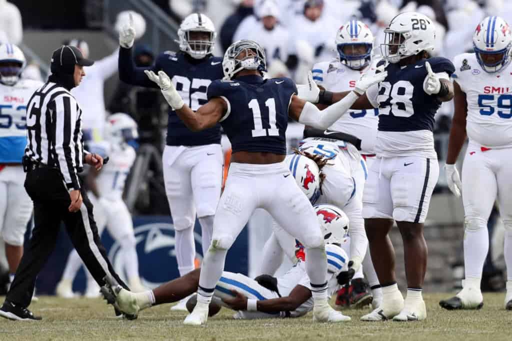 Throwing a touchdown pass during an intense college football game, showcasing team spirit and athletic performance on the field with players in inside the star uniforms.