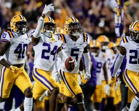 Louisiana State University (LSU) football players celebrating on the field during a game, wearing purple and gold uniforms, showcasing team spirit and athletic excellence in college football.