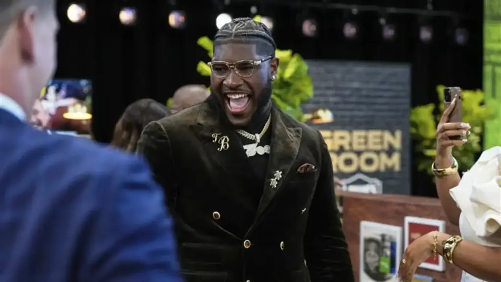 Vibrant celebration at Inside The Star event, featuring a smiling man in stylish black blazer, gold jewelry, and trendy glasses, surrounded by attendees, with a backdrop reading 'Green Room'.