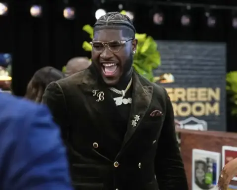 Vibrant celebration at Inside The Star event, featuring a smiling man in stylish black blazer, gold jewelry, and trendy glasses, surrounded by attendees, with a backdrop reading 'Green Room'.