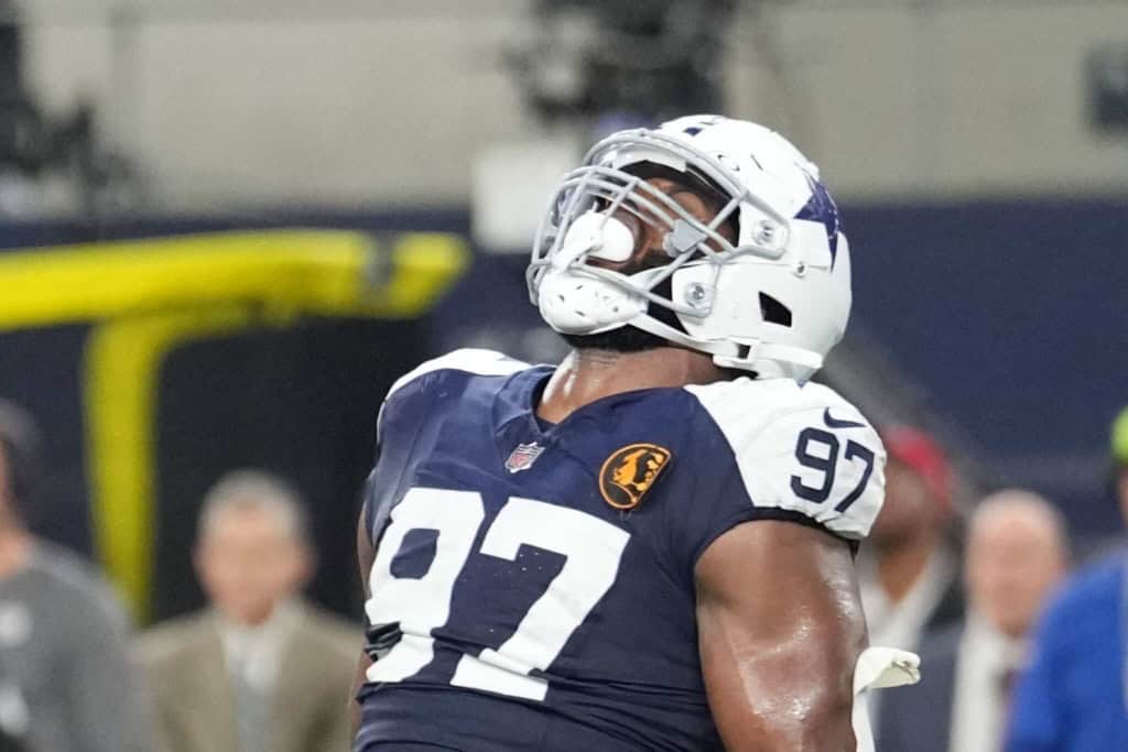 High school football player wearing Dallas Cowboys helmet and jersey number 97 on the field.