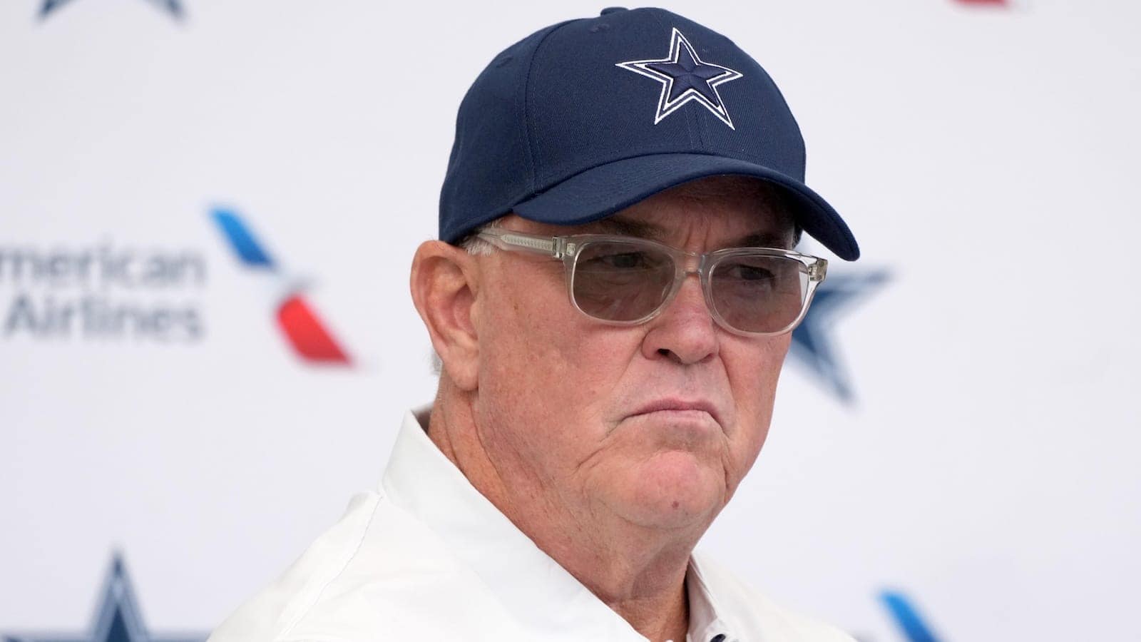 Focused image of an older man wearing a Dallas Cowboys cap and glasses, at an Inside The Star event, highlighting NFL football, Dallas Cowboys, team owner, and sports media coverage.