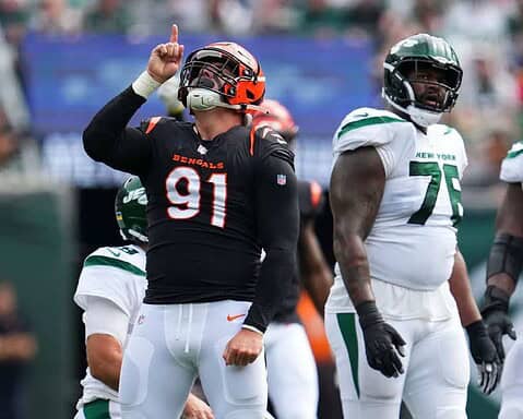 Cincinnati Bengals player celebrating a touchdown during an NFL game against the New York Jets, with teammates and crowd in the background.