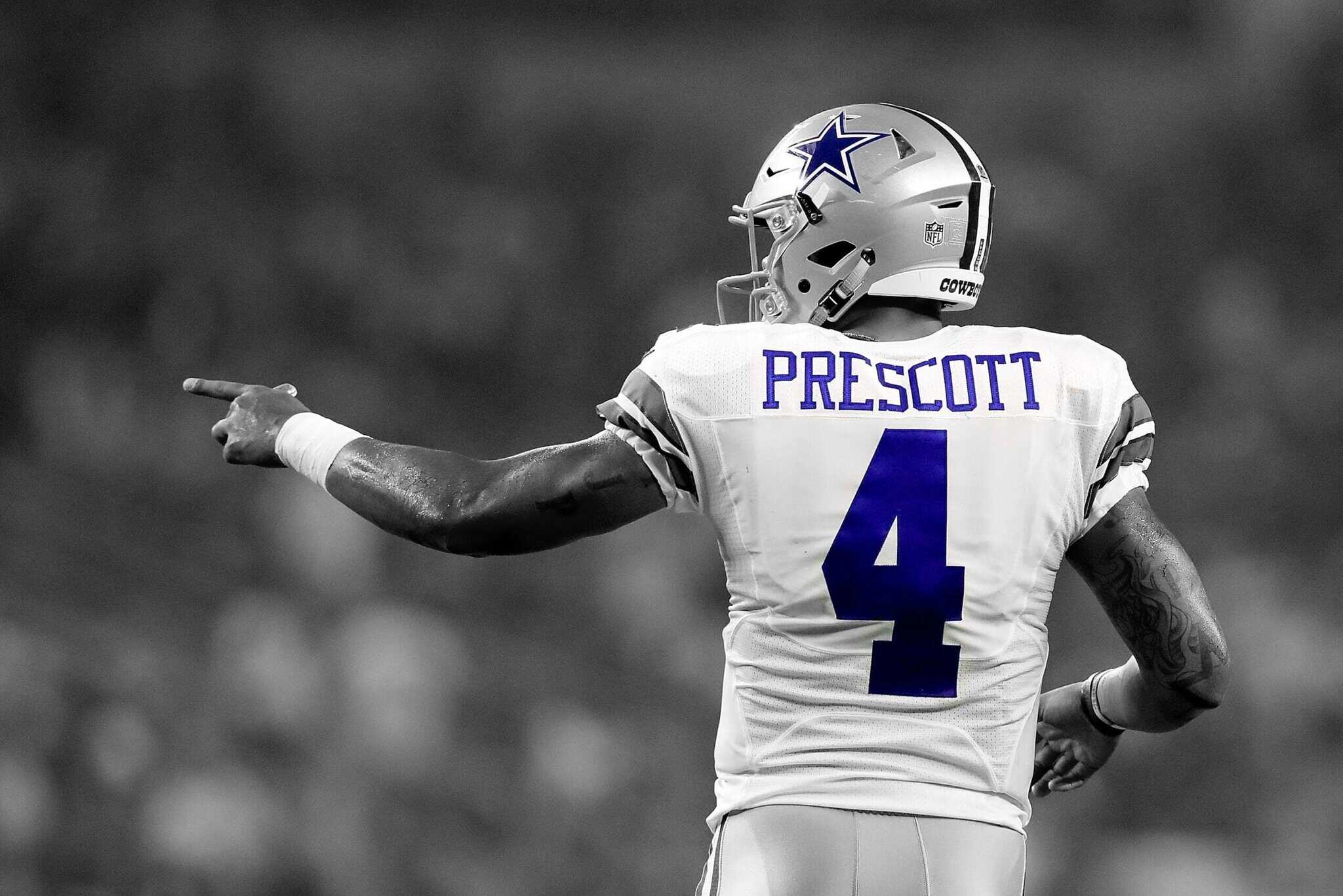 Dallas Cowboys quarterback Dak Prescott in action during a game, wearing his team uniform and helmet, pointing with his right hand, promoting NFL football excitement and team spirit.