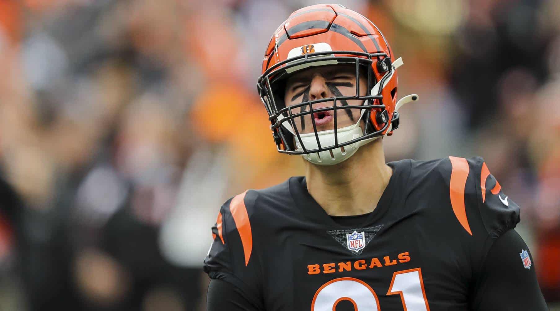 Fierce Cincinnati Bengals football player wearing helmet and black jersey on field during game, focusing on team spirit, NFL sports action, and game intensity.