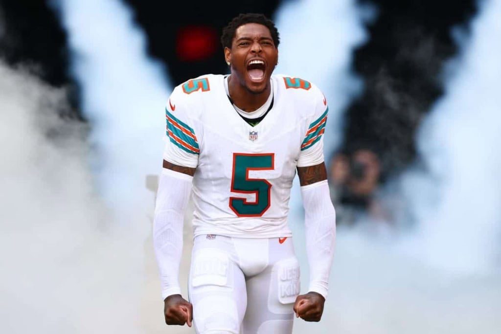 Explosive Miami Dolphins player celebrating on the field during an NFL game.
