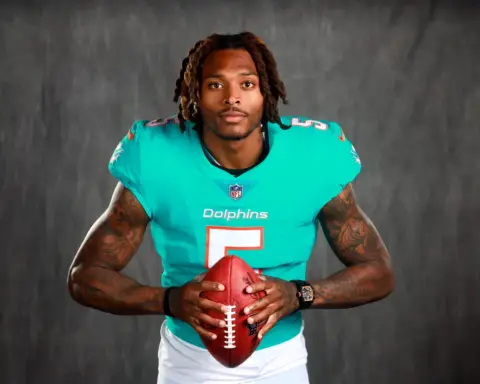 Cedric Wilson Jr. in Miami Dolphins football uniform holding a football, showcasing a player profile from Inside The Star, with a dark gray background.