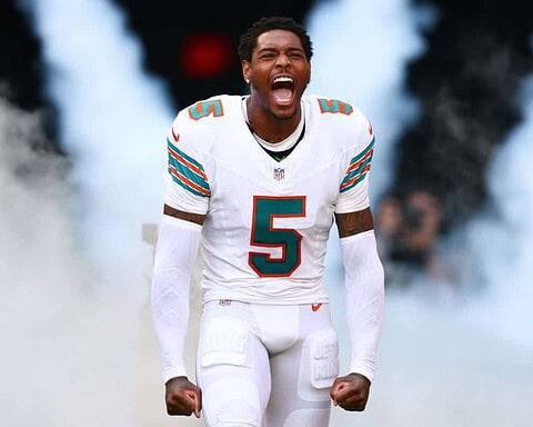 Explosive Miami Dolphins player celebrating on the field during an NFL game.