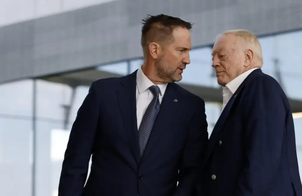 Focused Dallas Cowboys executives in formal suits engaging in a close discussion outside the stadium, emphasizing team management, leadership, and NFL team operational insights.