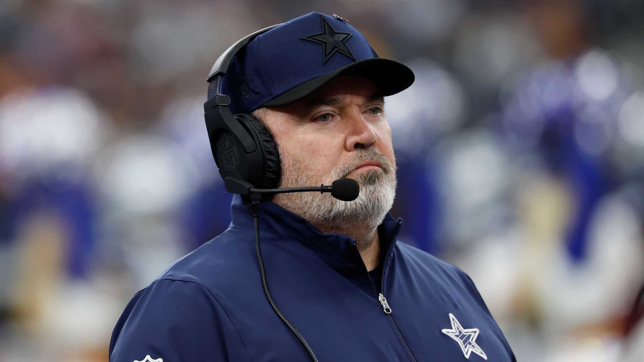 Focused Dallas Cowboys coach wearing headset, stadium background, NFL team gear, coaching staff, game day analysis, sports strategy, football coaching, inside the star.