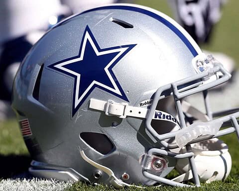 Dallas Cowboys football helmet on the field, featuring the team's iconic star logo, representing NFL team pride and football sports culture.