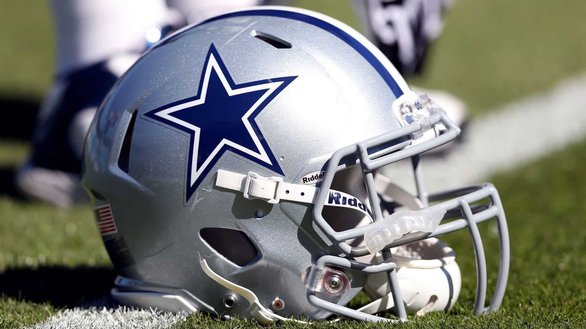 Dallas Cowboys football helmet on the field, featuring the team's iconic star logo, representing NFL team pride and football sports culture.