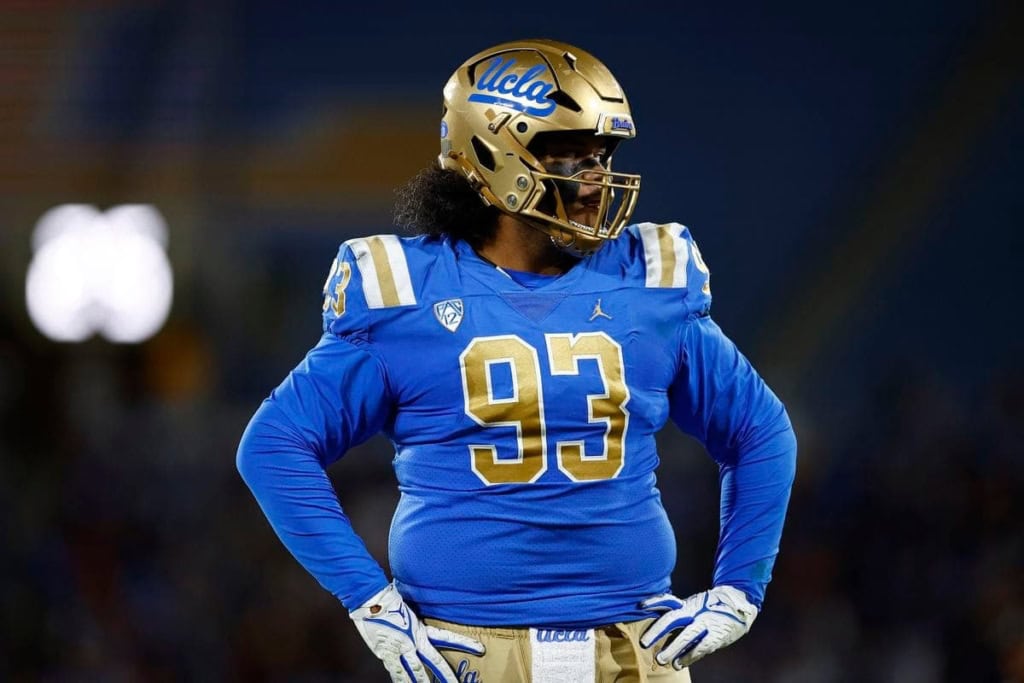 UCLA football player wearing a blue jersey and gold helmet on the field, showcasing team pride and athletic performance.