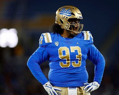 UCLA football player wearing a blue jersey and gold helmet on the field, showcasing team pride and athletic performance.
