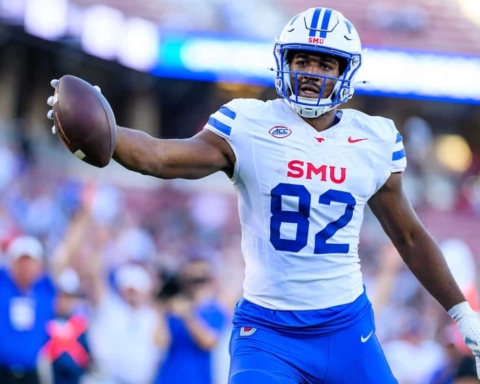 Highlights of a college football player in action, wearing a white and blue uniform with the number 82, holding a football on the field during a game at SMU.