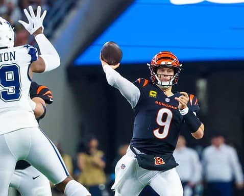 Cincinnati Bengals quarterback throwing a football against the Dallas Cowboys defense during an NFL game. Focus on action-packed moment showcasing team rivalry and football excitement.