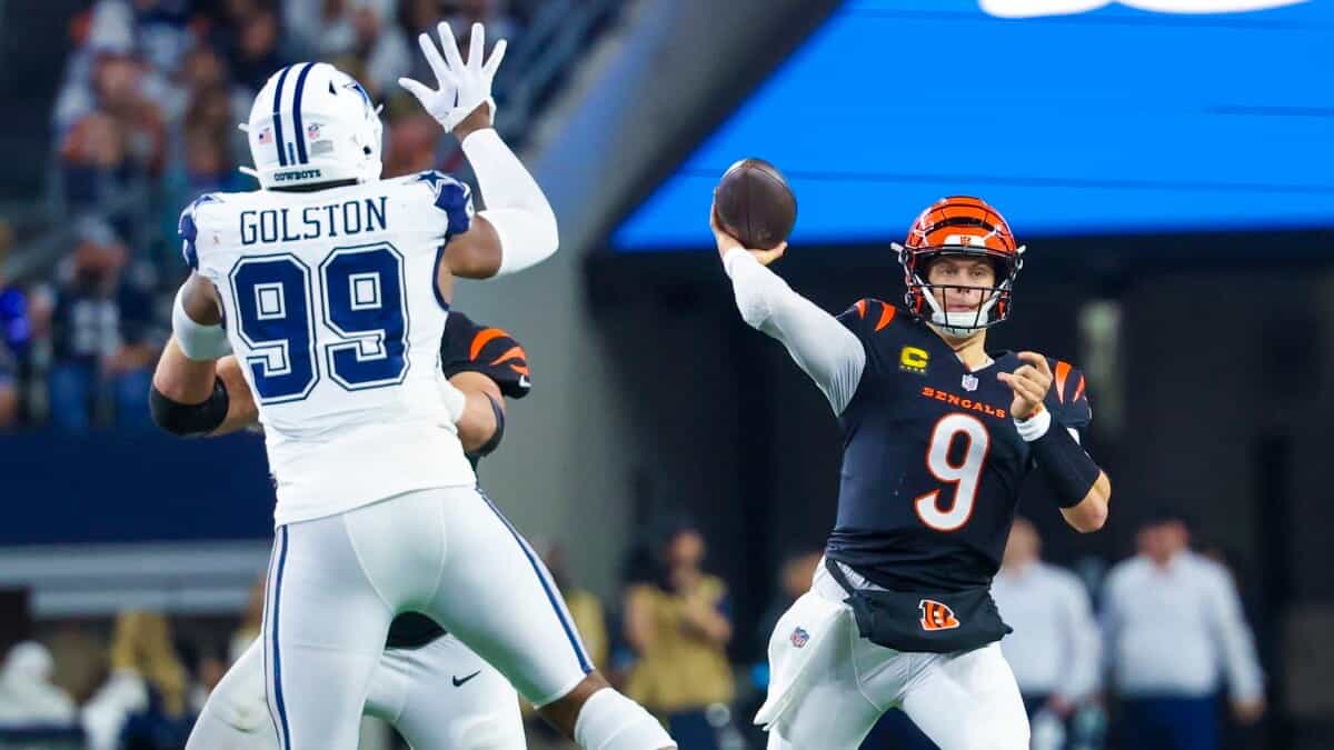 Cincinnati Bengals quarterback throwing a football against the Dallas Cowboys defense during an NFL game. Focus on action-packed moment showcasing team rivalry and football excitement.