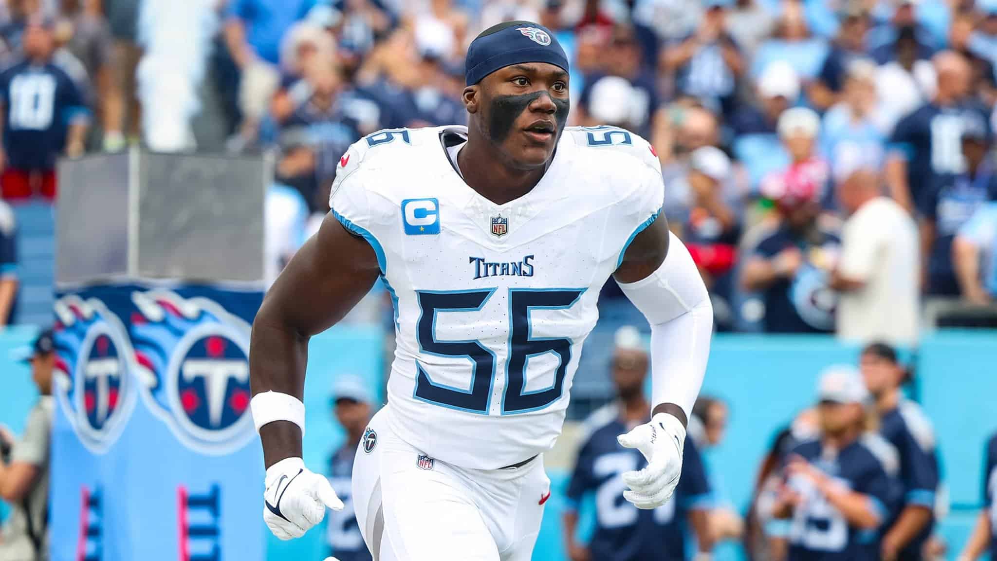 Running football player in Tennessee Titans uniform with face paint, on the field during game, highlighting NFL athlete, sports, American football, team, passion, athletic performance, Inside The Star.