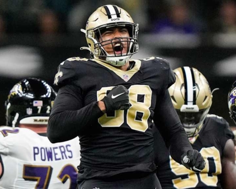 Hard football player celebrating victory with teammates on the field, wearing Black and Gold uniform, representing the New Orleans Saints.