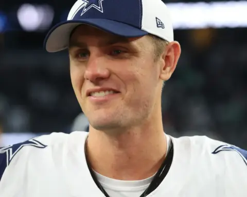 Young male Dallas Cowboys football player wearing team cap and jersey, smiling after game, inside the star stadium, NFL sports, athlete, sports photography.